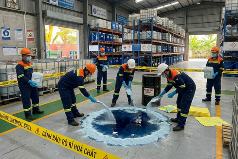 Nhân viên dùng bột Na2CO3 trung hòa axit H2SO4 bị rò rỉ trên sàn xưởng